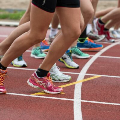 Close-up of athletes' feet at the starting line, prepared for a track race.